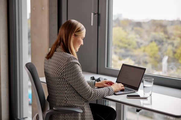 Office Managerin von netgo am Laptop arbeitend