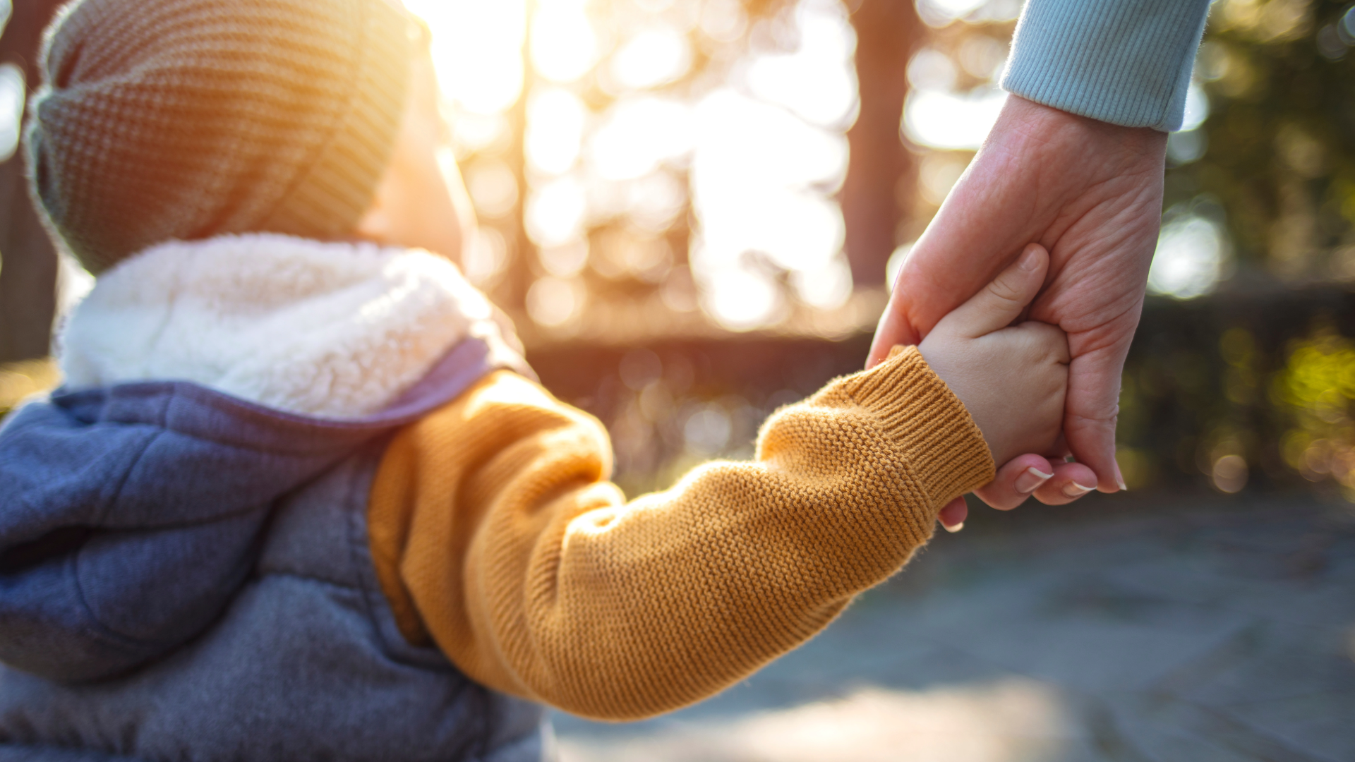 Bild von einem Kind und einem Elternteil, die sich an den Händen festhalten, als symbolische Darstellung für den netgo Benefit "Familienfreundlichkeit"
