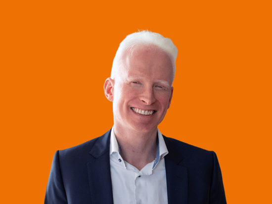 Portrait eines netgo Mitarbeitenden mit orangenem Hintergrund