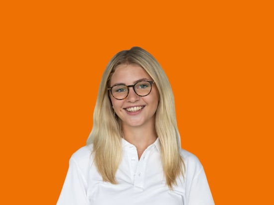 Portrait einer netgo Mitarbeitenden mit orangenem Hintergrund