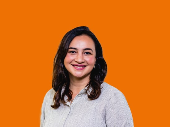 Portrait einer netgo Mitarbeitenden mit orangenem Hintergrund