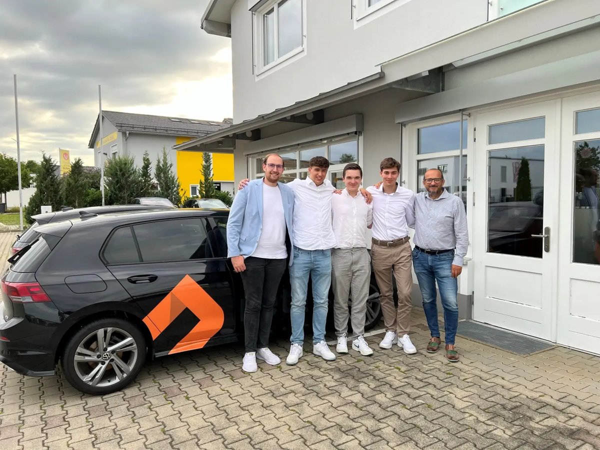 Gruppenfoto einiger Kolleg:innen vor Auto mit abgebildetem netgo Logo
